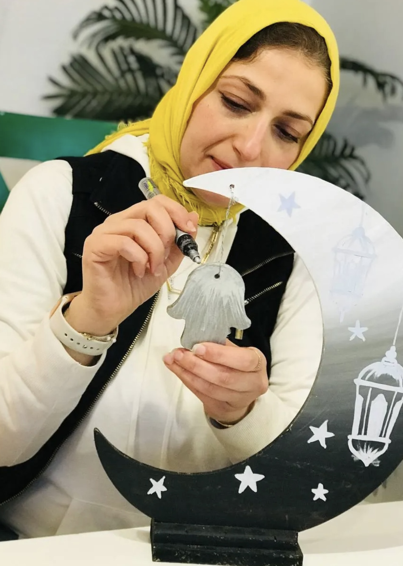 A student holding a watercolour painting of an old camera